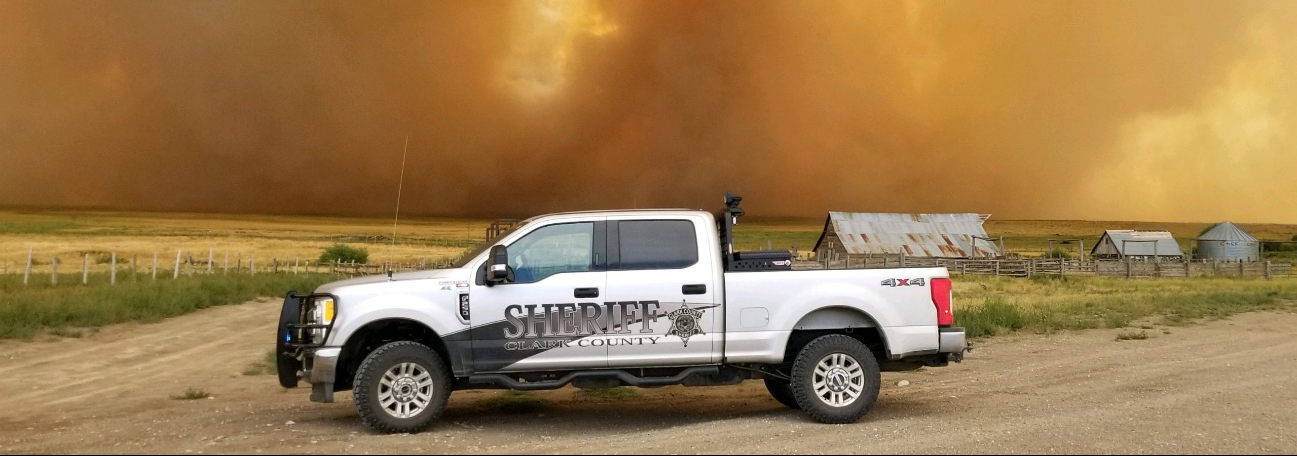 A truck in front of a large wall of fire